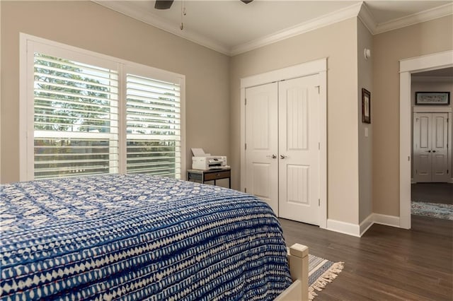 bedroom with baseboards, dark wood finished floors, a ceiling fan, crown molding, and a closet