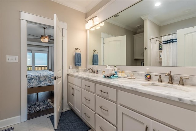 ensuite bathroom with double vanity, a sink, a ceiling fan, and crown molding