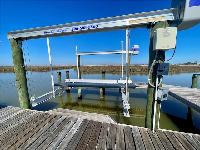 dock area with a water view and boat lift