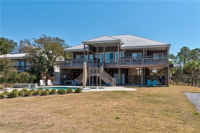 rear view of house with a fenced in pool, a yard, a patio, and stairs