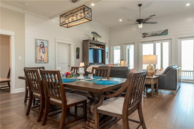 dining space with ornamental molding, a wealth of natural light, dark wood-type flooring, and a ceiling fan