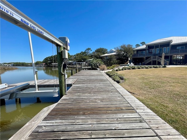 view of dock featuring a water view and a lawn