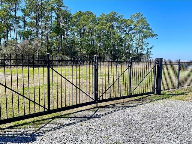 view of gate featuring fence and a lawn