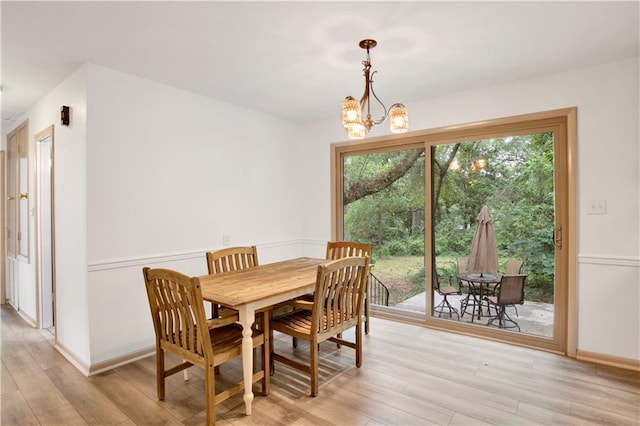 dining area with a healthy amount of sunlight, light wood-type flooring, and a chandelier