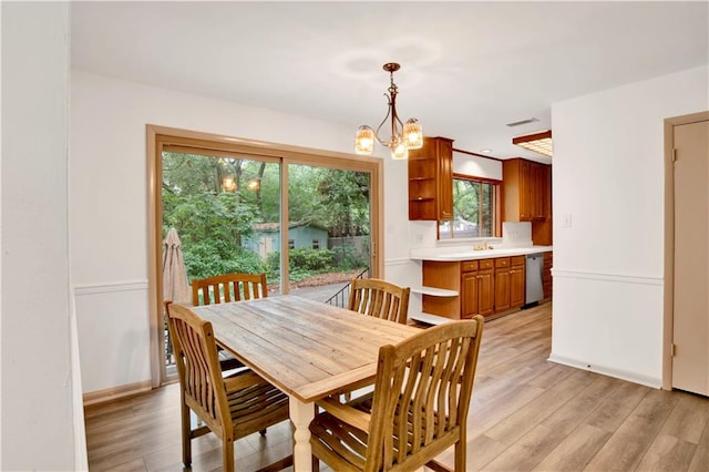 dining room with a notable chandelier and light hardwood / wood-style flooring