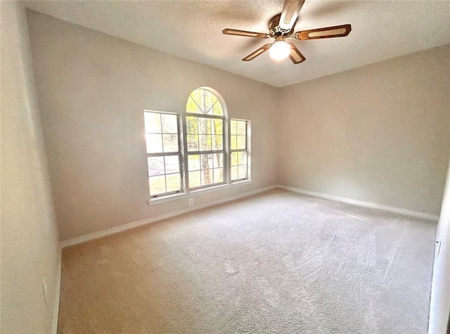 empty room featuring a textured ceiling, carpet flooring, and ceiling fan