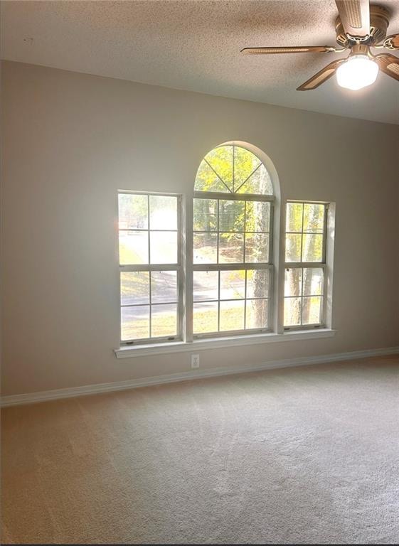 unfurnished room featuring carpet floors, a textured ceiling, and ceiling fan