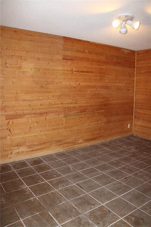 unfurnished room featuring wood walls