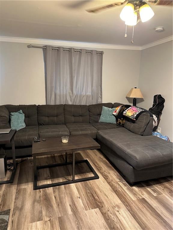 living room with crown molding, light hardwood / wood-style floors, and ceiling fan