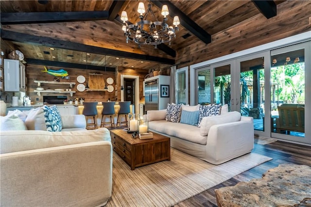 living room with wood walls, hardwood / wood-style floors, wood ceiling, a chandelier, and lofted ceiling with beams