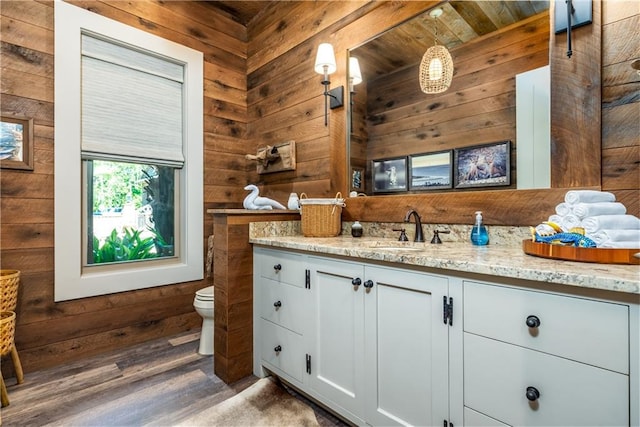 bathroom with wood ceiling, toilet, wooden walls, and vanity