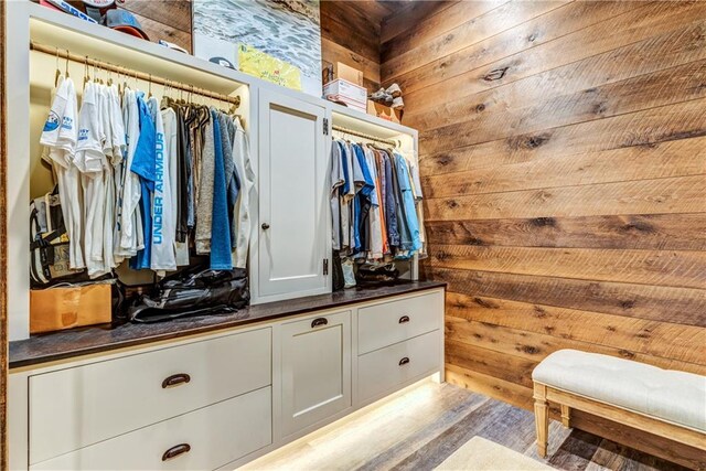 walk in closet with light hardwood / wood-style flooring