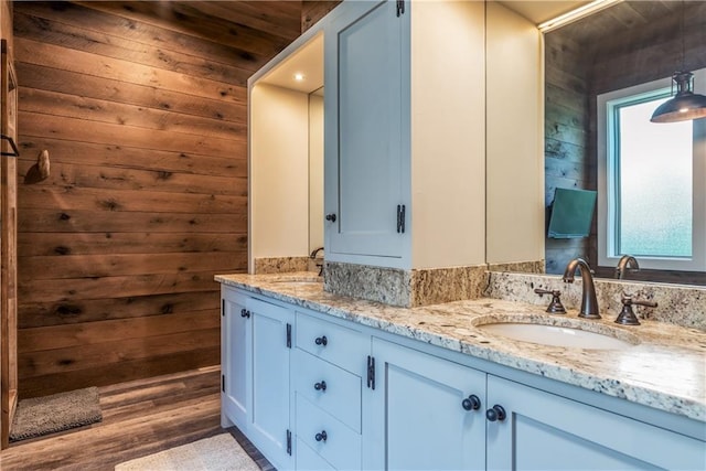 bathroom featuring vanity and wood walls