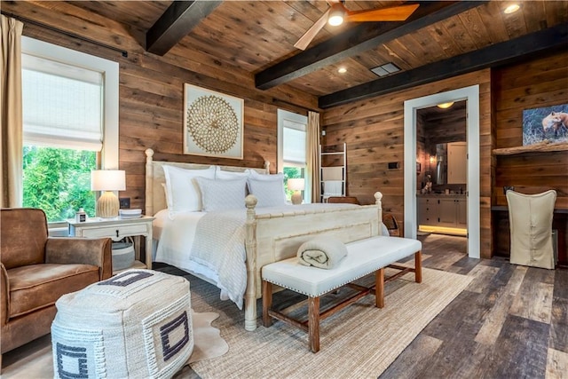 bedroom with multiple windows, hardwood / wood-style flooring, wooden ceiling, beam ceiling, and connected bathroom