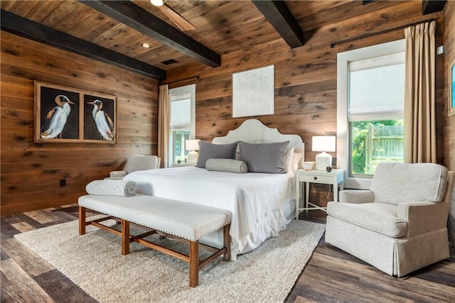 bedroom with wooden ceiling, wooden walls, beam ceiling, and wood finished floors