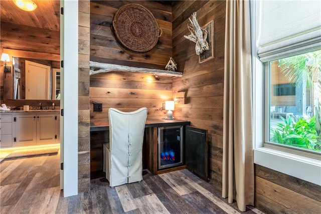 bar with dark hardwood / wood-style floors, wooden ceiling, sink, wooden walls, and white cabinets