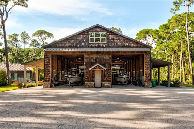 view of front of property with a detached garage, a standing seam roof, metal roof, a pole building, and an outdoor structure