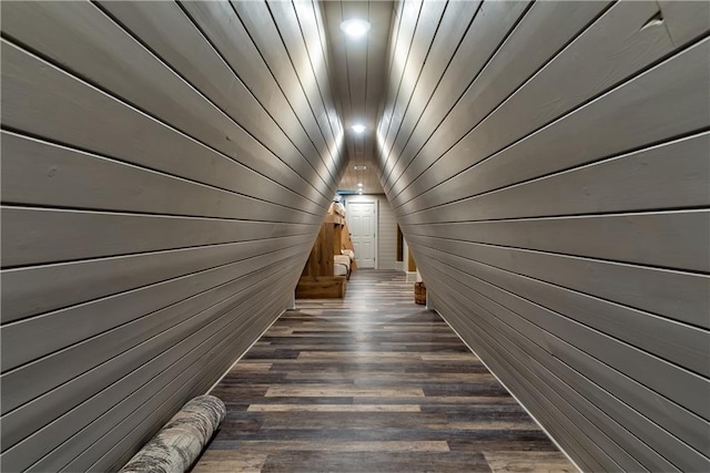 interior space featuring lofted ceiling, wood walls, and dark hardwood / wood-style flooring