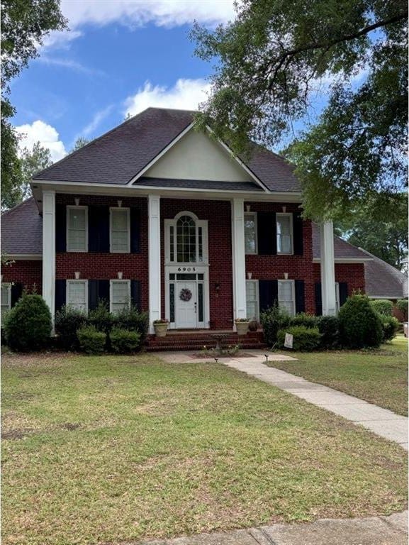 6905 Providence Estates Dr N, Mobile, AL 36695 - greek revival house with brick siding, a front yard, and covered porch