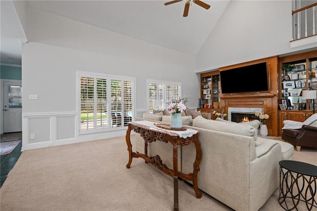 6905 Providence Estates Dr N, Mobile, AL 36695 - carpeted living area featuring ceiling fan, high vaulted ceiling, a premium fireplace, and a wainscoted wall