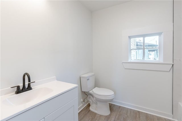 bathroom featuring vanity, hardwood / wood-style floors, and toilet