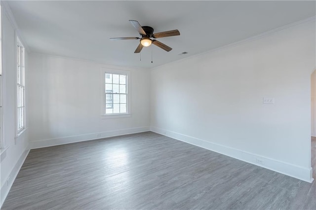 empty room with dark wood-type flooring, ceiling fan, and ornamental molding