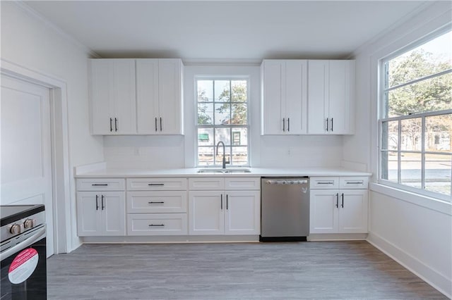 kitchen with stainless steel appliances, sink, white cabinets, and light wood-type flooring