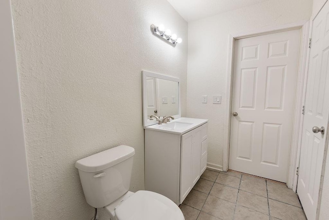 bathroom with vanity, toilet, and tile patterned flooring