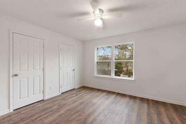 unfurnished bedroom with ceiling fan, wood-type flooring, and a textured ceiling