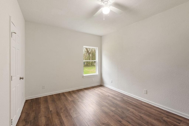 unfurnished room featuring dark wood-type flooring and ceiling fan