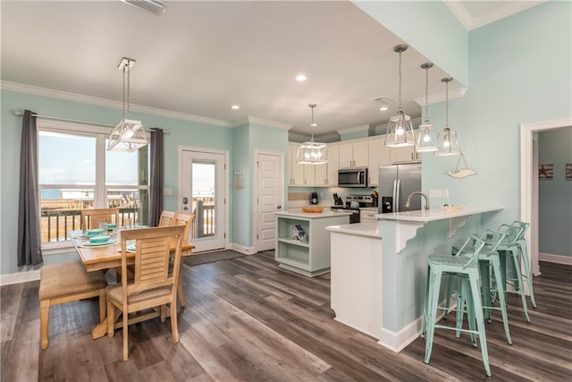 kitchen featuring a peninsula, light countertops, appliances with stainless steel finishes, open shelves, and pendant lighting