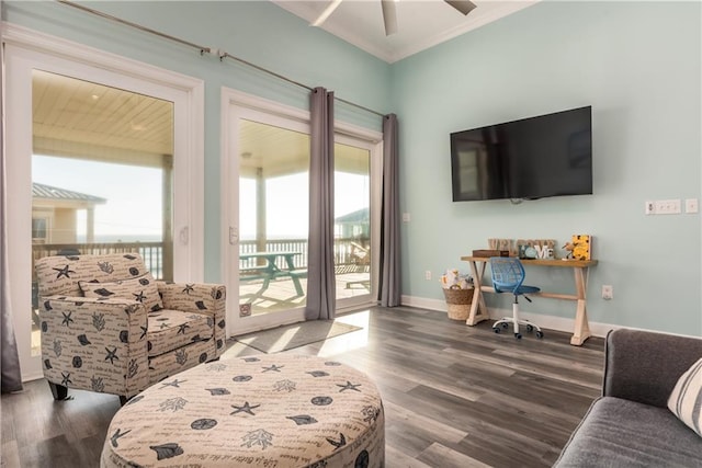 living area featuring crown molding, baseboards, ceiling fan, and wood finished floors