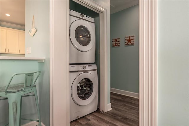 washroom featuring dark wood finished floors, stacked washer and dryer, recessed lighting, laundry area, and baseboards