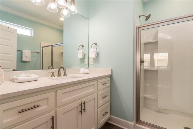 bathroom with a stall shower, crown molding, vanity, and baseboards