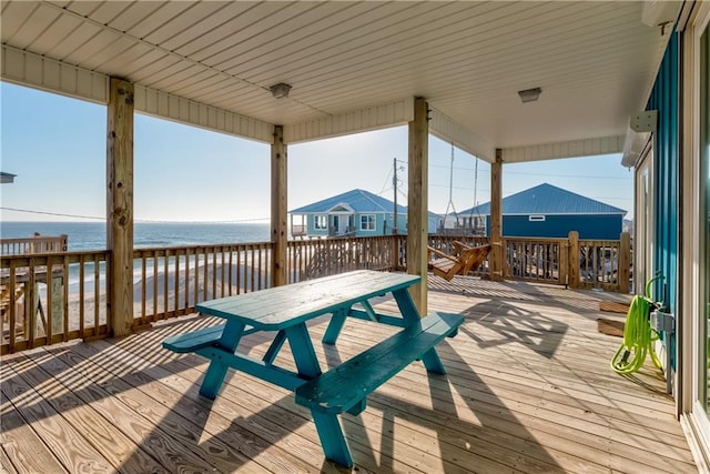 deck featuring outdoor dining area and a water view