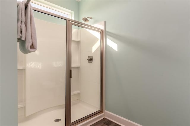 bathroom featuring a stall shower and baseboards