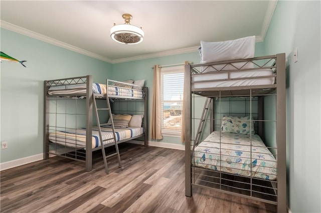 bedroom featuring baseboards, crown molding, and wood finished floors