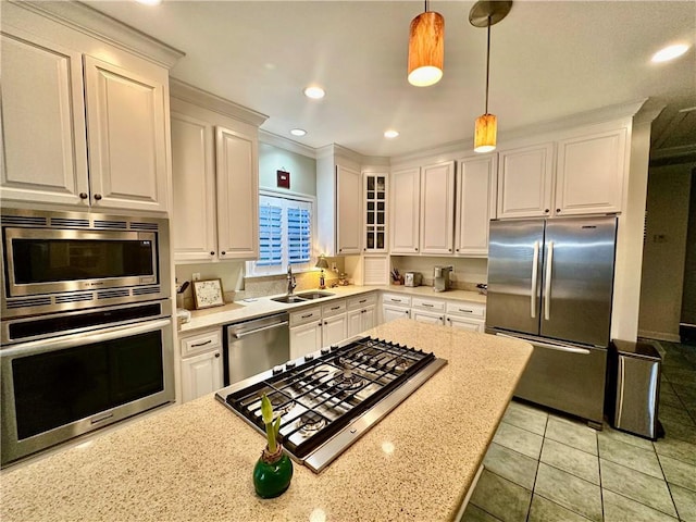 kitchen with light stone countertops, sink, stainless steel appliances, decorative light fixtures, and white cabinets