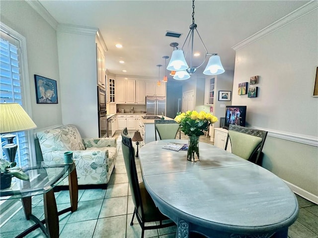 dining area featuring light tile patterned flooring, crown molding, and a chandelier