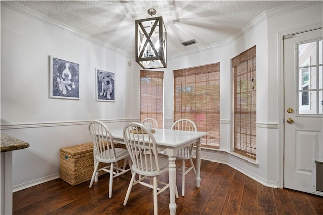 dining room with a textured ceiling, visible vents, ornamental molding, and wood-type flooring
