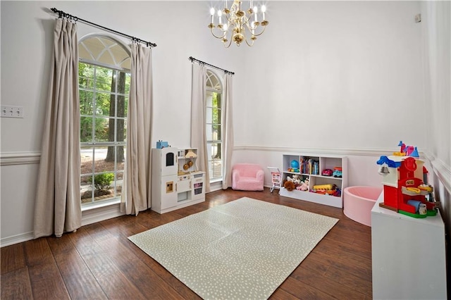 rec room featuring an inviting chandelier and dark wood finished floors