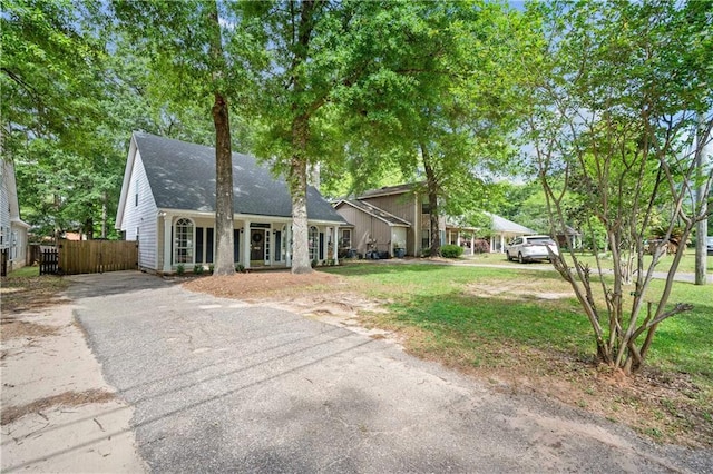 view of front of house featuring a front yard, fence, and aphalt driveway