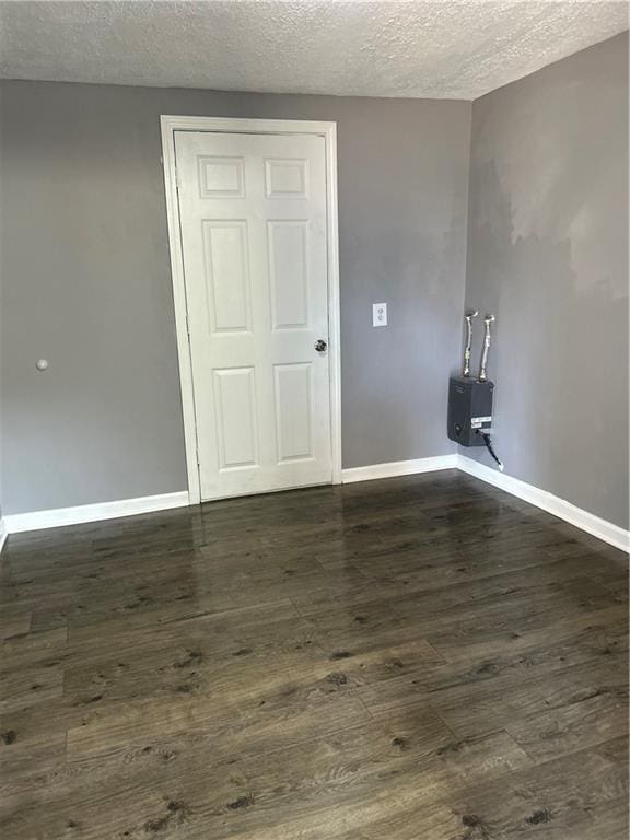 unfurnished room with dark hardwood / wood-style floors and a textured ceiling