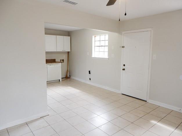 unfurnished room featuring a ceiling fan, baseboards, light tile patterned floors, and visible vents