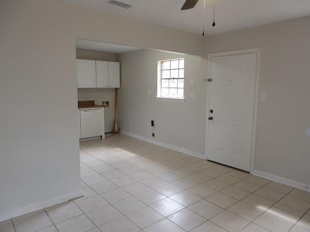empty room with visible vents, baseboards, light tile patterned flooring, and ceiling fan