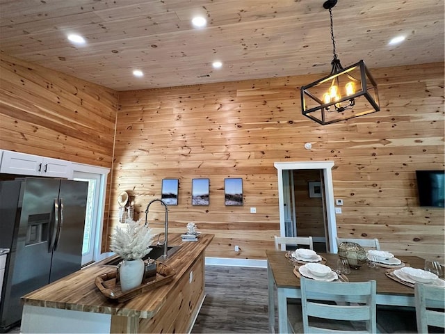 1401 Osprey Ln, Dauphin Island, AL 36528 - kitchen with dark wood-style flooring, stainless steel fridge with ice dispenser, white cabinets, butcher block counters, and a notable chandelier