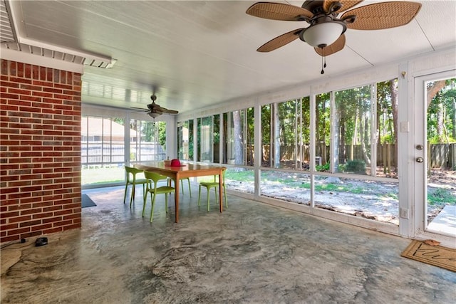 unfurnished sunroom featuring ceiling fan and a healthy amount of sunlight