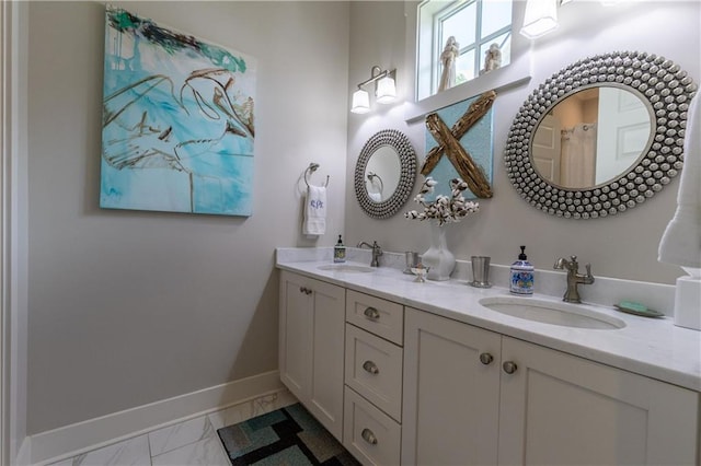 full bath featuring marble look tiles, baseboards, and double vanity