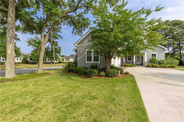 view of front of property with concrete driveway and a front lawn
