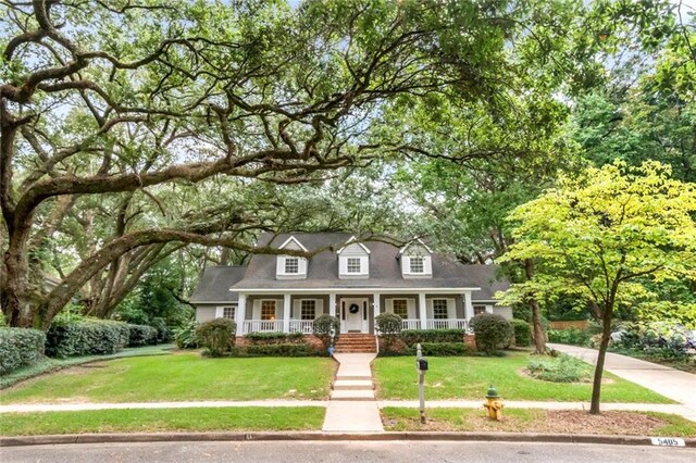 cape cod-style house featuring a porch and a front yard